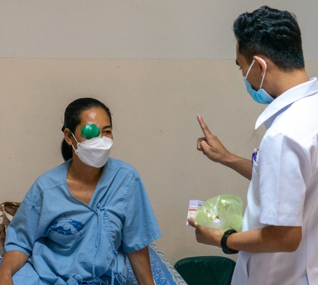 Arzt mit Patient, der sich von einer Kataraktoperation erholt